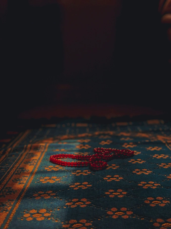 a red string laying on top of a blue rug